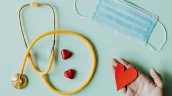 a stethoscope, a medical mask, and a paper heart