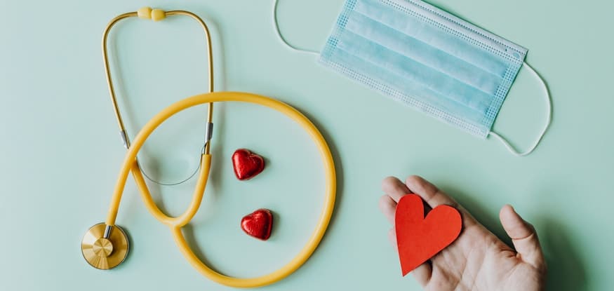 a stethoscope, a medical mask, and a paper heart