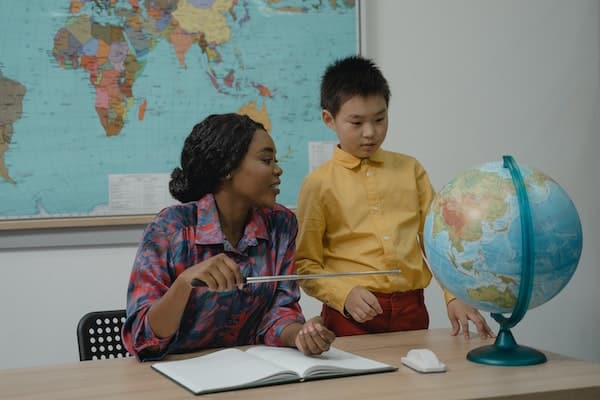 a teachers explains a globe to a student